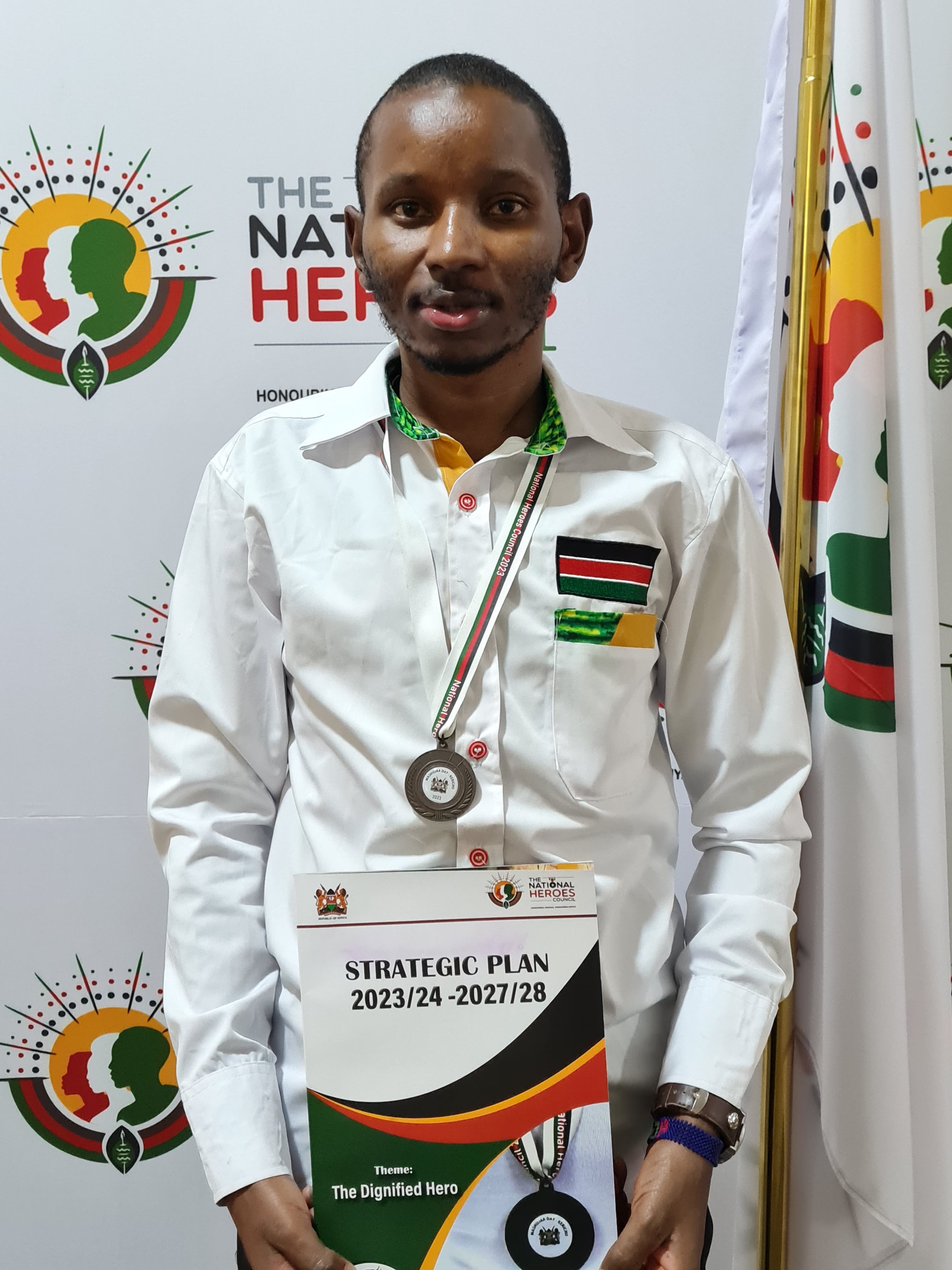 John Kamau holding his Presidential Heroes Award medal